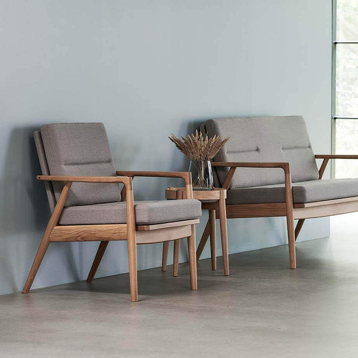 sofa serie, model Nobel 8981 og 8982, stel i massiv natur eg og polster i lys grå tekstil, stående langs med blå væg på beton gulv
